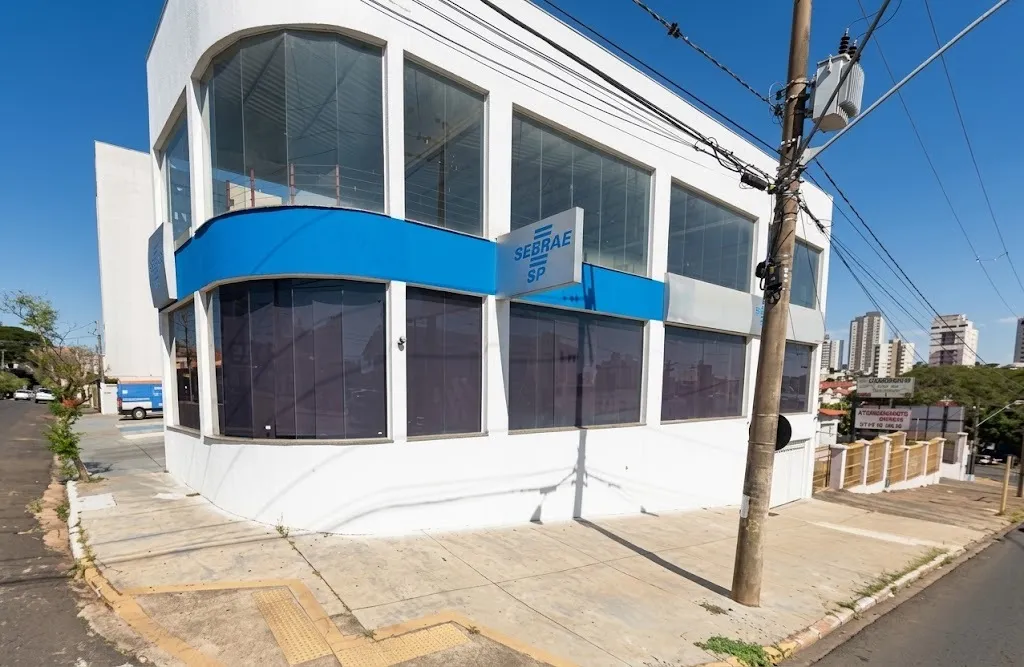 fachada de um prédio banco e azul com blindez e placa escrito sebrae