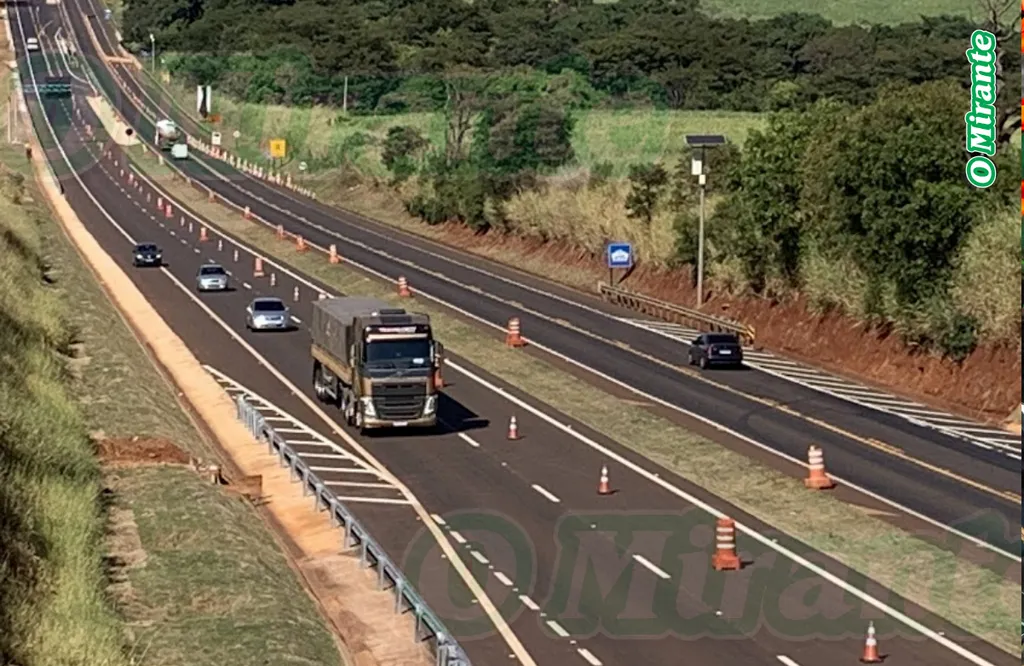 estrada com carreta e carros ao fundo com cones de interdição ao longo da extensão