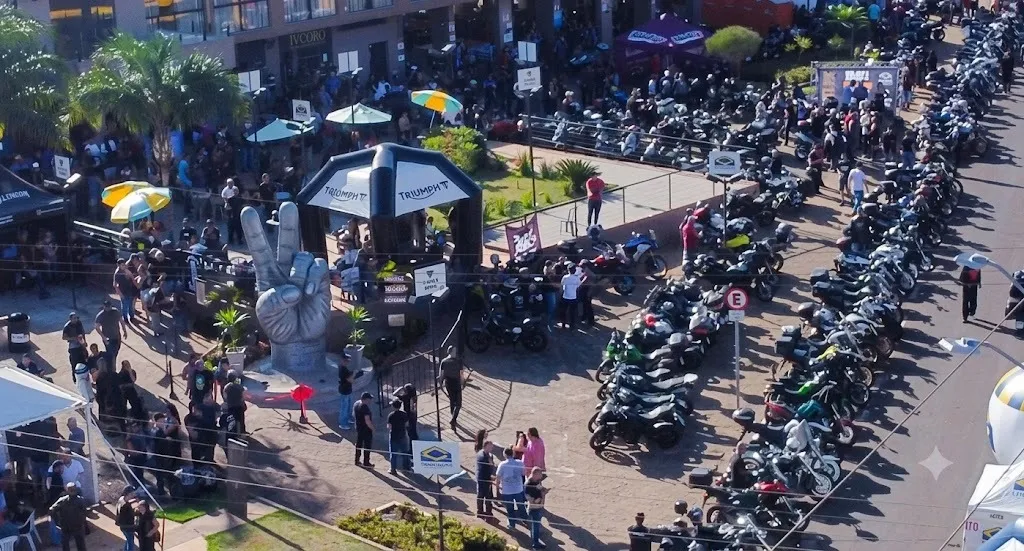 vista área de praça de hotel com dezenas de motos e pessas em confraternização