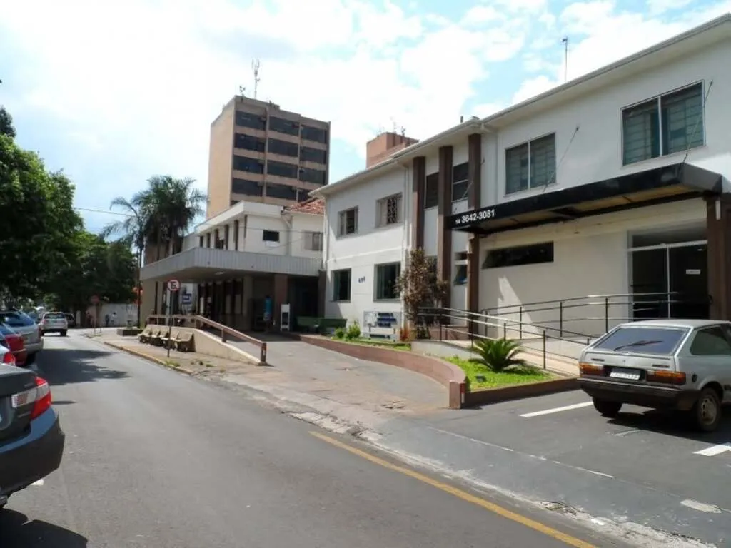 prédio com entrada frontal, contendo veículos estacionados em 45 graus do lado esquerdo, com placas de trânsito do lado oposto