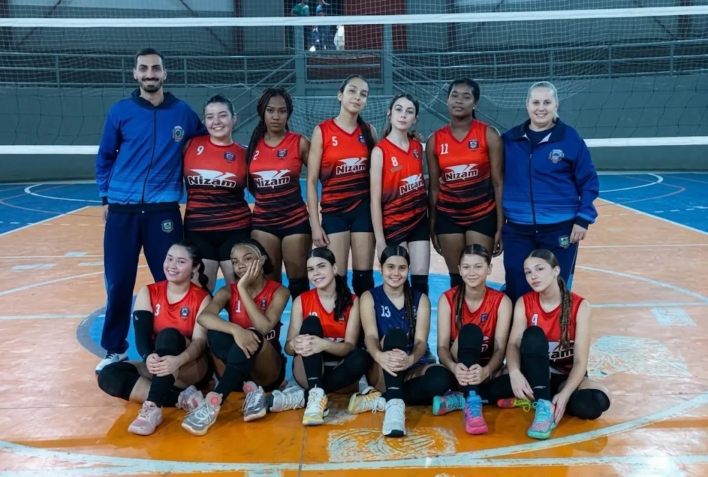 equipe de mulheres com uniforme vermelho numa quadra
