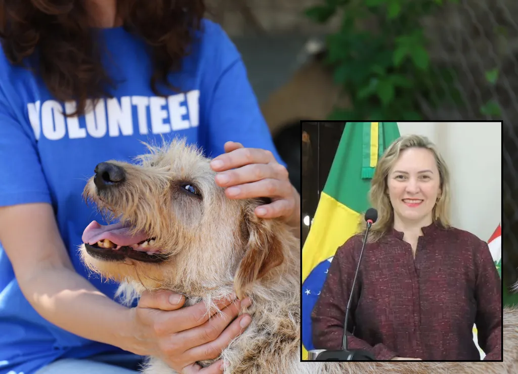 Mulher acaricia cachorro, no destaque, outra mulher sorri atrás de uma tribuna de vidro com um microfone, tendo ao fundo três bandeiras