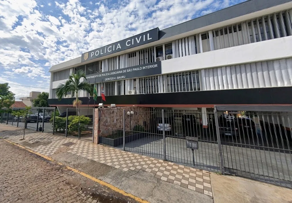 Prédio cercado por grades, com placa na fachada escrito Polícia Civil com letras brancas